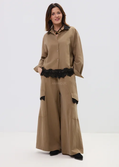 Koszula oversize w kolorze brązowym z czarną koronką przy kołnierzu i dole, o luźnym kroju z długim rękawem.