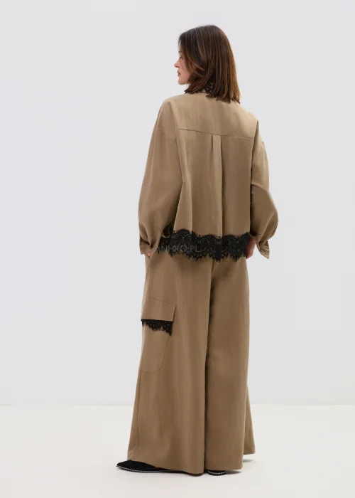 Koszula oversize w kolorze brązowym z czarną koronką przy kołnierzu i dole, o luźnym kroju z długim rękawem.
