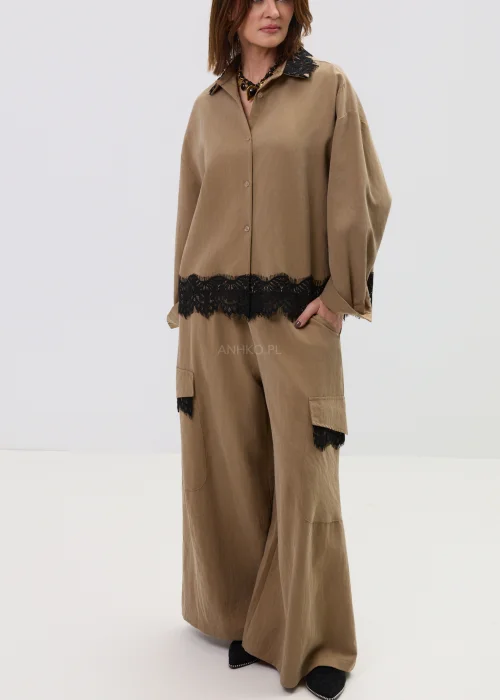 Koszula oversize w kolorze brązowym z czarną koronką przy kołnierzu i dole, o luźnym kroju z długim rękawem.