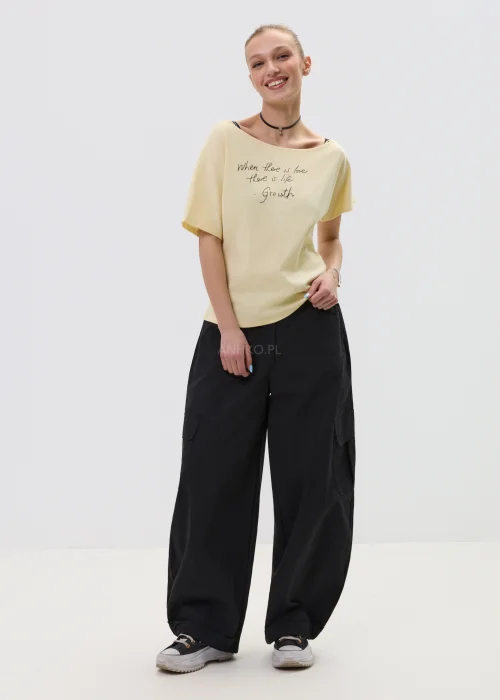 Żółta bluzka damska z krótkim rękawem i napisem „When there is love there is life – Growth”, luźny fason, casualowa stylizacja.