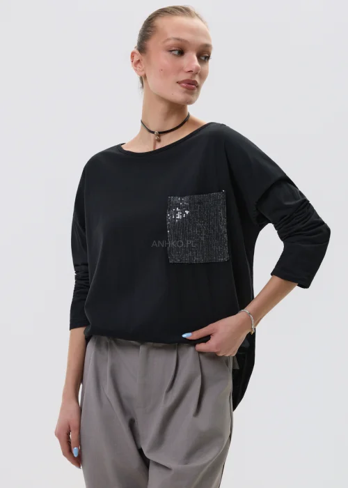 Czarna bluzka damska z długim rękawem i kieszonką zdobioną cekinami, luźny fason, elegancko-casualowa stylizacja.