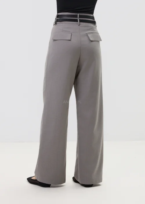 Szare spodnie damskie z wysokim stanem i szerokimi nogawkami, elegancki fason z zakładkami w nowoczesnej stylizacji.