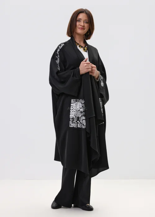 Czarne kimono damskie o luźnym, oversize’owym kroju z szerokimi rękawami i nadrukiem typograficznym, stylizacja w nowoczesnym, streetwearowym klimacie.