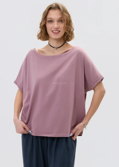 Wrzosowa bluzka oversize z krótkim rękawem i szerokim dekoltem, zestawiona z luźnymi spodniami w casualowej stylizacji.