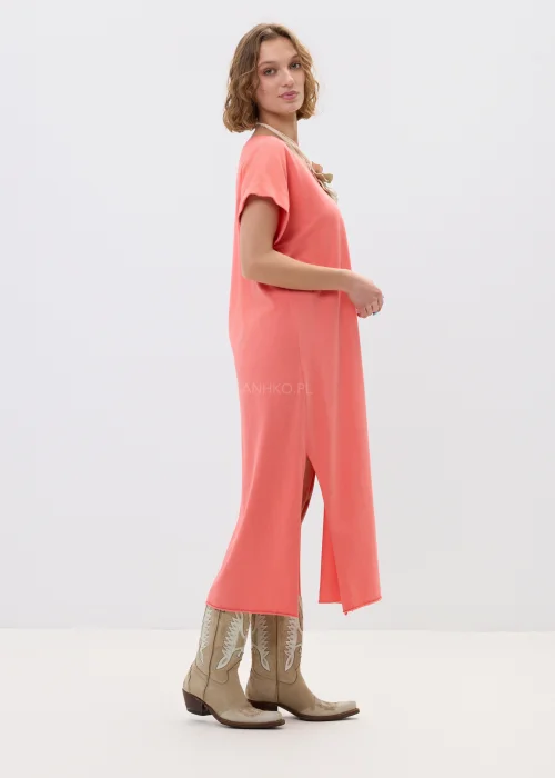 Koralowa sukienka maxi o luźnym, oversize’owym kroju z krótkim rękawem i dekoltem w serek, zestawiona z kowbojkami w stylizacji casual boho.