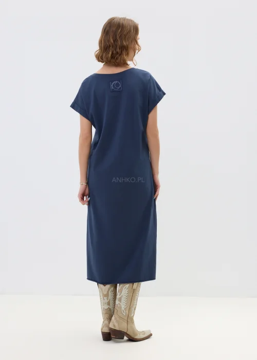 Granatowa sukienka midi o luźnym, oversize’owym kroju z krótkim rękawem i dekoltem w serek, zestawiona z kowbojkami i długim naszyjnikiem w stylizacji casual.
