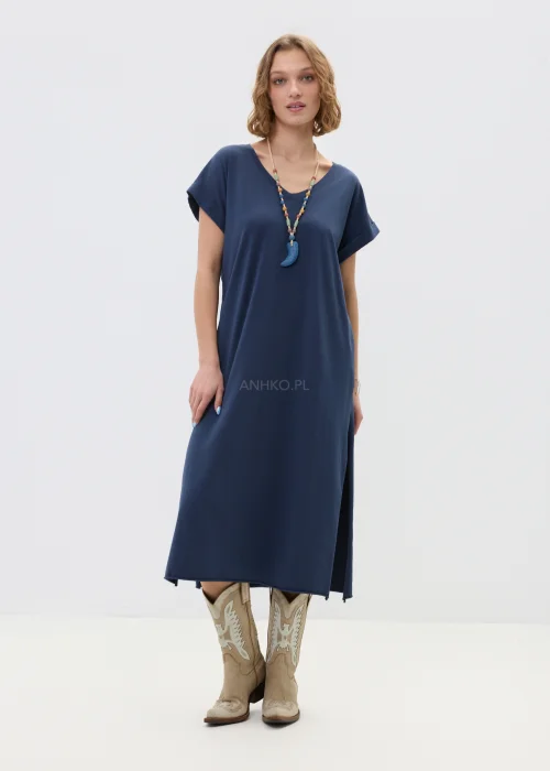 Granatowa sukienka midi o luźnym, oversize’owym kroju z krótkim rękawem i dekoltem w serek, zestawiona z kowbojkami i długim naszyjnikiem w stylizacji casual.