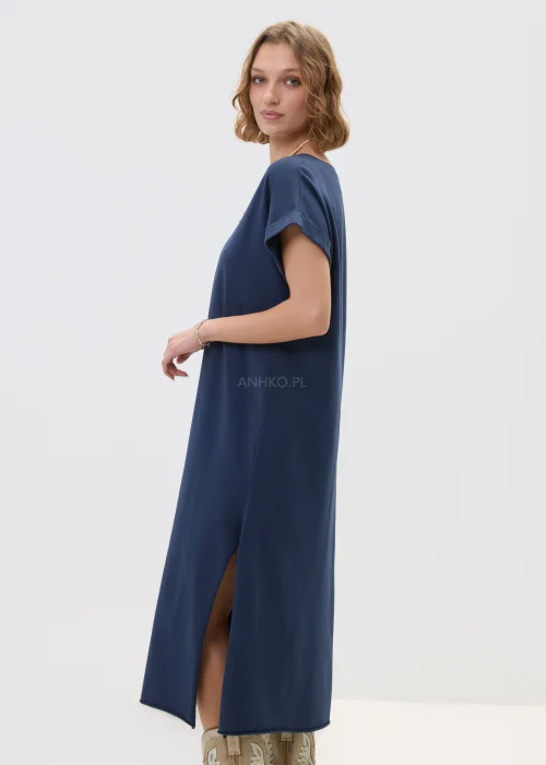 Granatowa sukienka midi o luźnym, oversize’owym kroju z krótkim rękawem i dekoltem w serek, zestawiona z kowbojkami i długim naszyjnikiem w stylizacji casual.