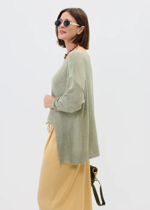 Szałwiowy sweter damski oversize z asymetrycznym dołem  stylizowany z luźnymi spodniami w casualowym looku.