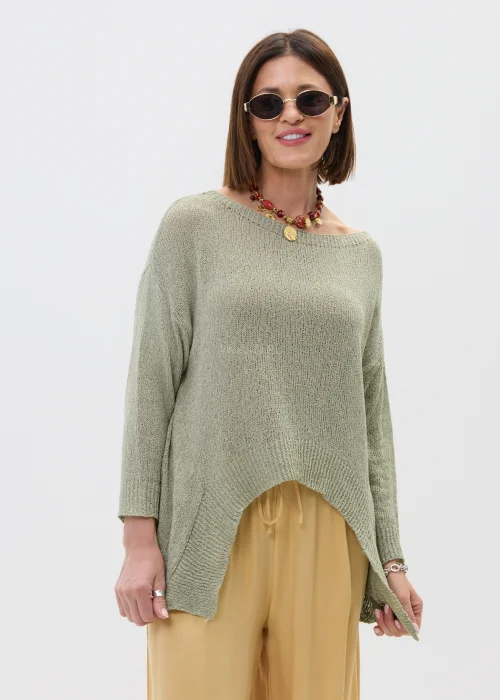 Szałwiowy sweter damski oversize z asymetrycznym dołem  stylizowany z luźnymi spodniami w casualowym looku.