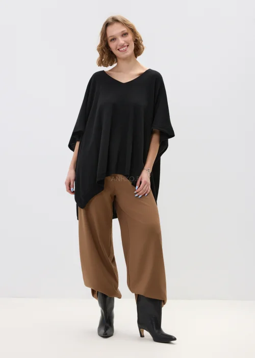 Czarny sweter damski z dodatkiem kaszmiru o luźnym, oversize’owym kroju z szerokimi rękawami i dekoltem w serek, w stylizacji z eleganckimi spodniami.