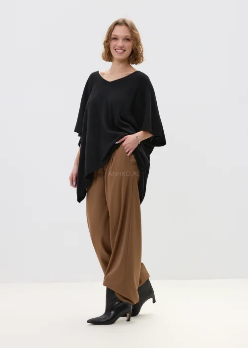 Czarny sweter damski z dodatkiem kaszmiru o luźnym, oversize’owym kroju z szerokimi rękawami i dekoltem w serek, w stylizacji z eleganckimi spodniami.