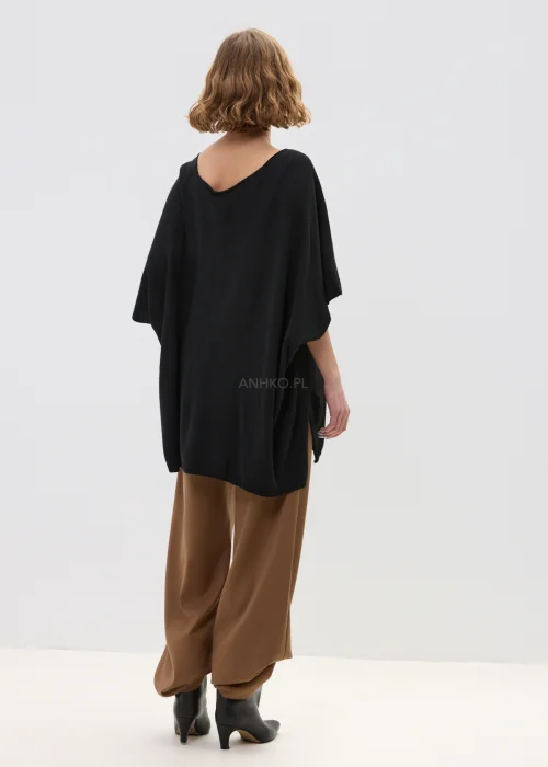 Czarny sweter damski z dodatkiem kaszmiru o luźnym, oversize’owym kroju z szerokimi rękawami i dekoltem w serek, w stylizacji z eleganckimi spodniami.