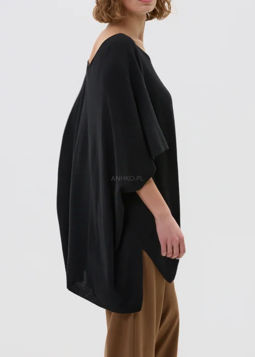 Czarny sweter damski z dodatkiem kaszmiru o luźnym, oversize’owym kroju z szerokimi rękawami i dekoltem w serek, w stylizacji z eleganckimi spodniami.