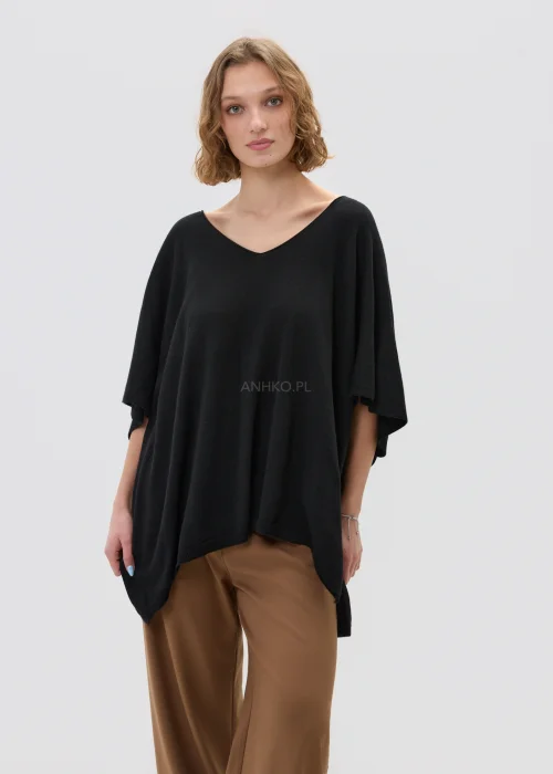 Czarny sweter damski z dodatkiem kaszmiru o luźnym, oversize’owym kroju z szerokimi rękawami i dekoltem w serek, w stylizacji z eleganckimi spodniami.