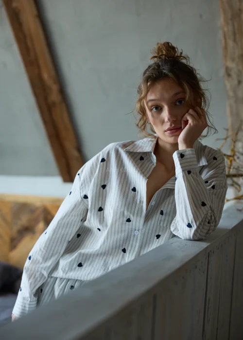 Piżama damska dwuczęściowa w kolorze ecru w delikatne paski i drobne serduszka, koszula zapinana na guziki i krótkie spodenki z luźnym, komfortowym krojem.