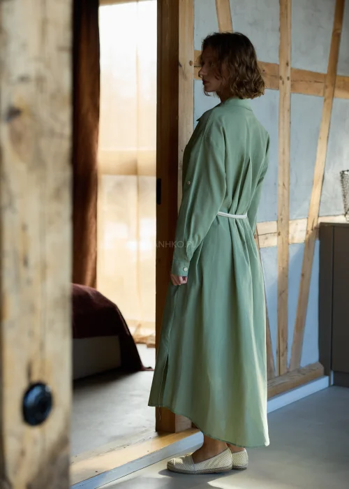 Zielona sukienka koszulowa midi z dodatkiem lnu, z paskiem w talii, zapinana na guziki, z długim rękawem, minimalistyczna stylizacja casual.
