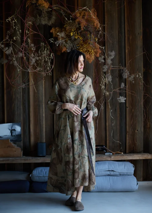 Brązowa sukienka lniana maxi w kwiatowy wzór z długim rękawem i paskiem w talii, luźny fason, styl naturalny i elegancki.