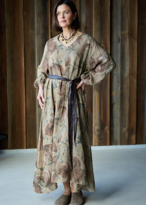 Brązowa sukienka lniana maxi w kwiatowy wzór z długim rękawem i paskiem w talii, luźny fason, styl naturalny i elegancki.