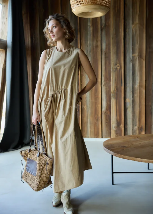 Camelowa sukienka midi o luźnym kroju bez rękawów, z asymetrycznym marszczeniem i rozcięciem, styl casual z kowbojkami.