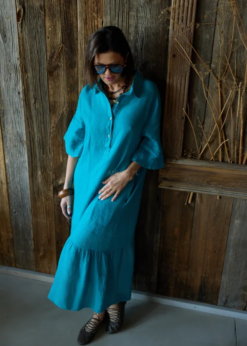 Turkusowa lniana sukienka midi o luźnym kroju z kołnierzykiem i guzikami, z falbaną u dołu i rękawem 3/4, styl casual z okularami przeciwsłonecznymi.