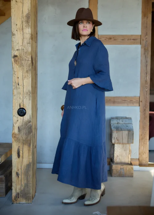 Granatowa lniana sukienka midi o luźnym kroju z kołnierzykiem i guzikami, z falbaną u dołu i rękawem 3/4, styl boho z kapeluszem i kowbojkami.