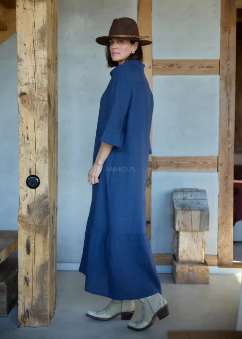 Granatowa lniana sukienka midi o luźnym kroju z kołnierzykiem i guzikami, z falbaną u dołu i rękawem 3/4, styl boho z kapeluszem i kowbojkami.