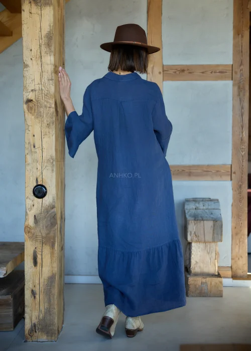Granatowa lniana sukienka midi o luźnym kroju z kołnierzykiem i guzikami, z falbaną u dołu i rękawem 3/4, styl boho z kapeluszem i kowbojkami.