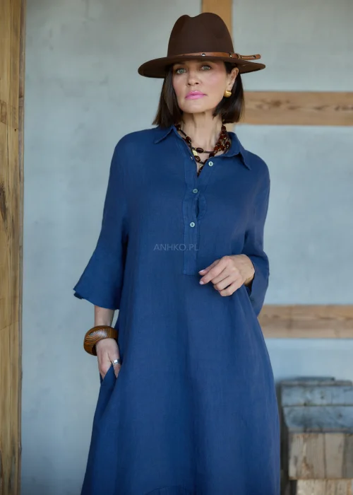 Granatowa lniana sukienka midi o luźnym kroju z kołnierzykiem i guzikami, z falbaną u dołu i rękawem 3/4, styl boho z kapeluszem i kowbojkami.