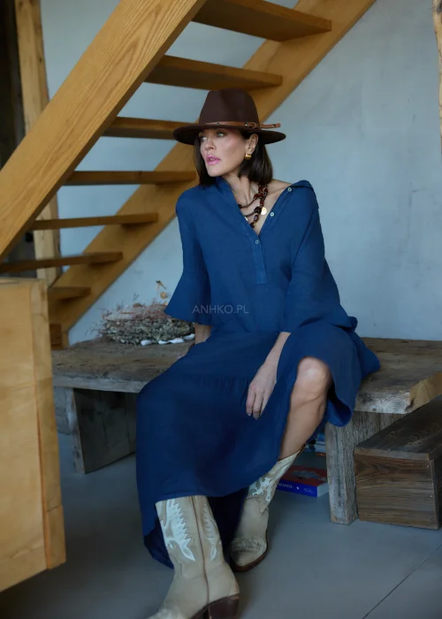 Granatowa lniana sukienka midi o luźnym kroju z kołnierzykiem i guzikami, z falbaną u dołu i rękawem 3/4, styl boho z kapeluszem i kowbojkami.