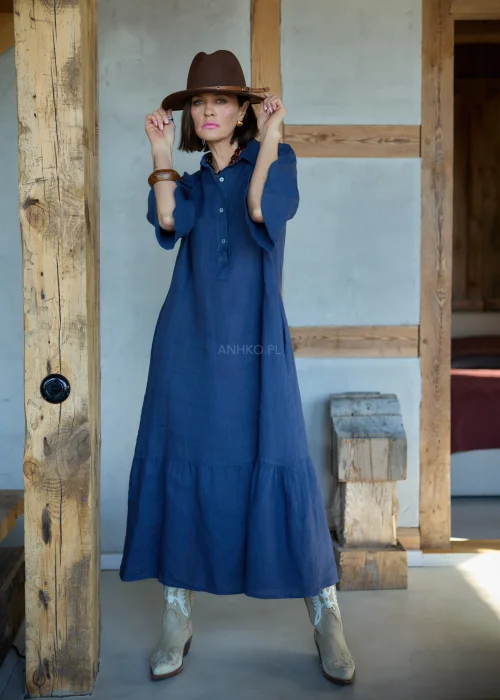 Granatowa lniana sukienka midi o luźnym kroju z kołnierzykiem i guzikami, z falbaną u dołu i rękawem 3/4, styl boho z kapeluszem i kowbojkami.
