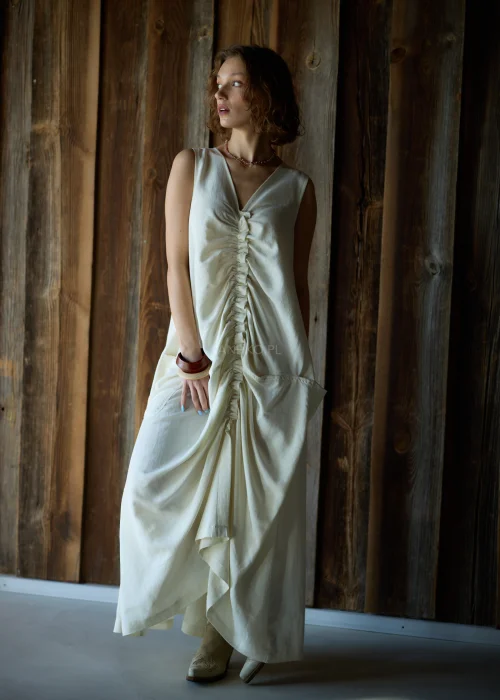 Kremowa sukienka maxi bez rękawów z szerokimi ramiączkami, marszczeniem z przodu i kieszeniami, o luźnym fasonie.