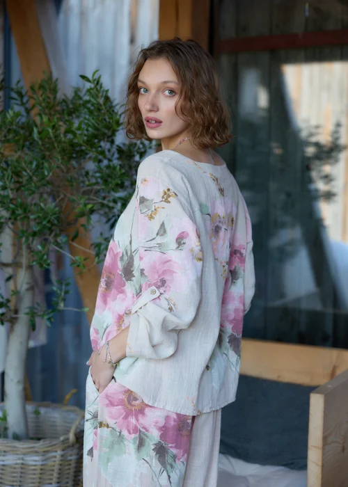 Beżowa bluzka damska z delikatnym kwiatowym printem, o luźnym kroju z rękawami 3/4.