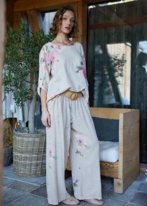 Beżowa bluzka damska z delikatnym kwiatowym printem, o luźnym kroju z rękawami 3/4.