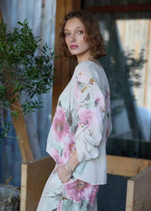 Beżowa bluzka damska z delikatnym kwiatowym printem, o luźnym kroju z rękawami 3/4.