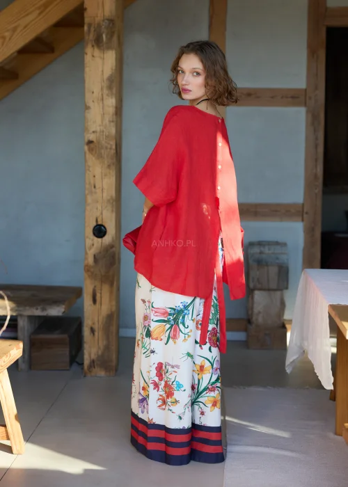 Białe spodnie damskie typu wide leg w kolorowy kwiatowy wzór z szeroką nogawką i elastycznym pasem, wykończone kontrastowym paskiem, styl casual premium.