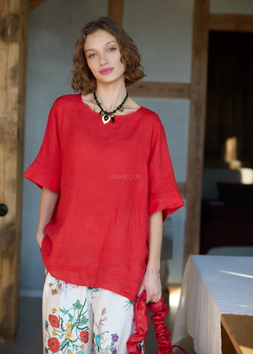 Lniana bluzka damska w intensywnym czerwonym kolorze z krótkim rękawem i wiązaniem na plecach, luźny fason, stylizacja z kwiatową spódnicą.