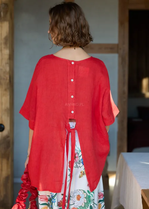 Lniana bluzka damska w intensywnym czerwonym kolorze z krótkim rękawem i wiązaniem na plecach, luźny fason, stylizacja z kwiatową spódnicą.