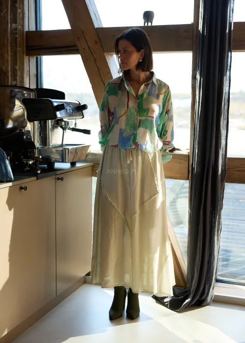 Beżowa spódnica midi z naturalnej tkaniny z surowymi przeszyciami i elastyczną talią, styl casual z botkami na obcasie.