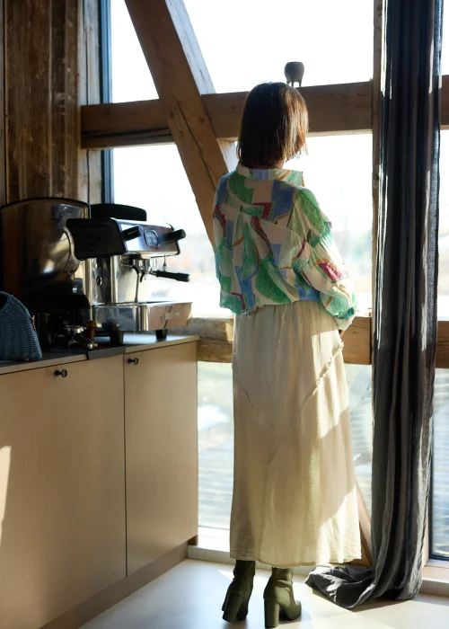 Beżowa spódnica midi z naturalnej tkaniny z surowymi przeszyciami i elastyczną talią, styl casual z botkami na obcasie.