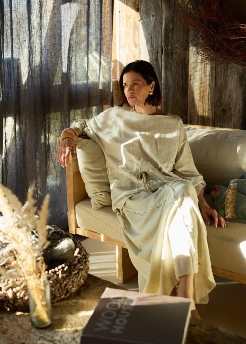 Beżowa spódnica midi z naturalnej tkaniny z surowymi przeszyciami i elastyczną talią, styl casual z botkami na obcasie.