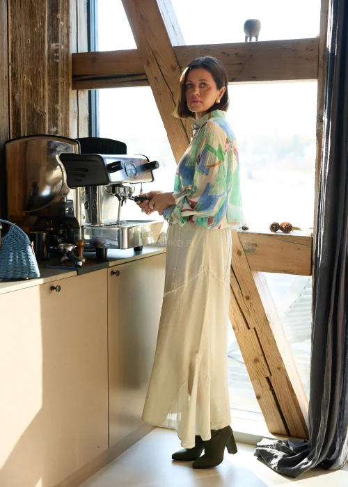 Koszula damska w geometryczny wzór w odcieniach zieleni, beżu i błękitu, o luźnym kroju, z kołnierzykiem i podwijanymi rękawami.