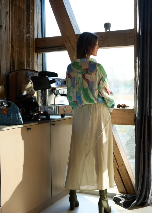 Koszula damska w geometryczny wzór w odcieniach zieleni, beżu i błękitu, o luźnym kroju, z kołnierzykiem i podwijanymi rękawami.