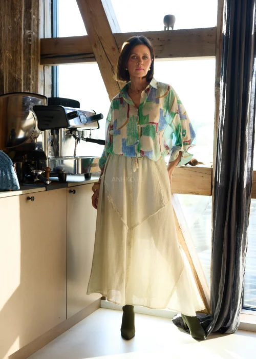 Koszula damska w geometryczny wzór w odcieniach zieleni, beżu i błękitu, o luźnym kroju, z kołnierzykiem i podwijanymi rękawami.