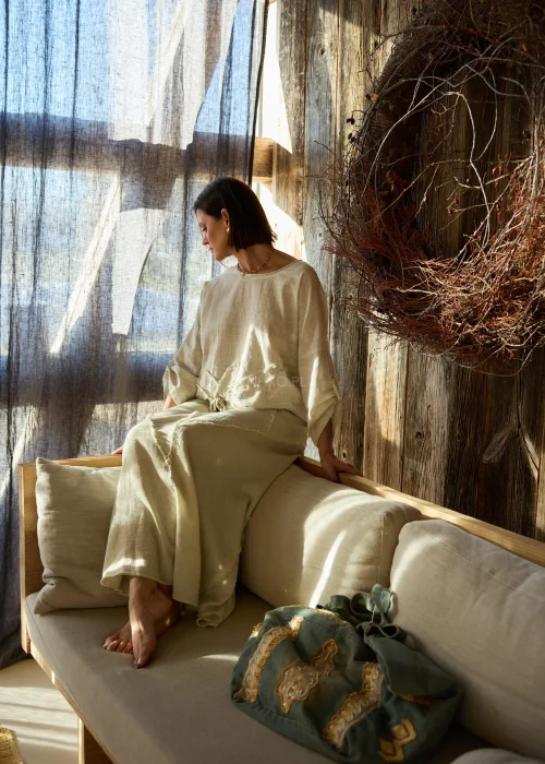 Bluzka damska w kolorze beżowym, z rękawem 3/4 i dekoracyjnym, surowym przeszyciem w formie kwiatowego motywu z wiązaniem z przodu.