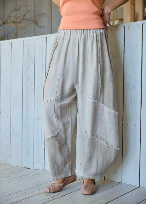 Spodnie damskie w kolorze taupe z dodatkiem lnu o luźnym kroju, z elastyczną talią i dekoracyjnymi przeszyciami, w stylu casualowym.