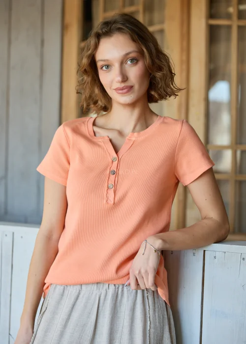 Bluzka damska prążkowana w kolorze brzoskwiniowym, z krótkim rękawem i dekoltem na guziki, o dopasowanym fasonie.