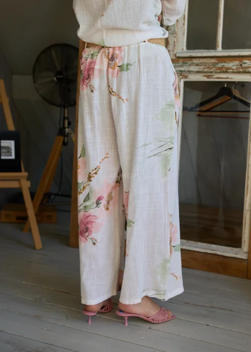 Spodnie damskie w kolorze białym z subtelnym kwiatowym printem, szerokie nogawki i wysoki stan z paskiem,