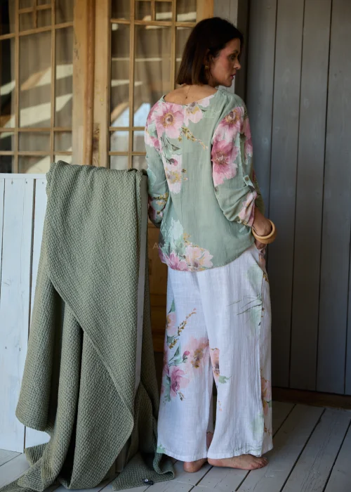 Spodnie damskie w kolorze białym z subtelnym kwiatowym printem, szerokie nogawki i wysoki stan z paskiem,