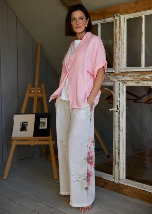 Spodnie damskie w kolorze białym z subtelnym kwiatowym printem, szerokie nogawki i wysoki stan z paskiem,